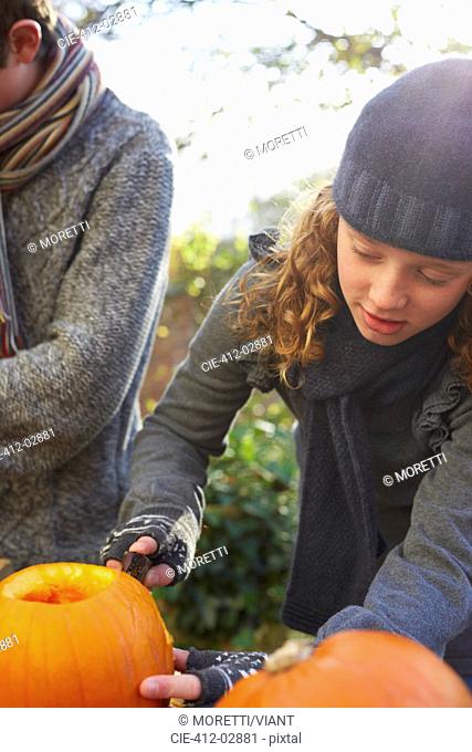 Children carving pumpkins together outdoors