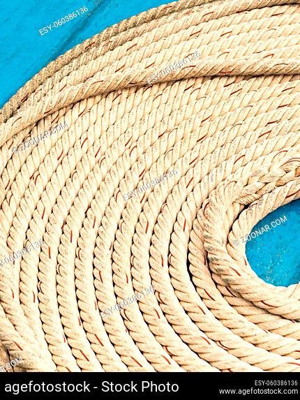 light braided rope part of marine fasteners, folded in a circle close-up, empty space in the middle