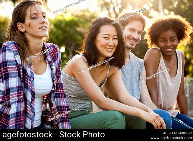 Group of young friends sitting together in park