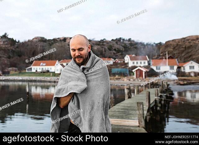 Man at lake wrapped in towel