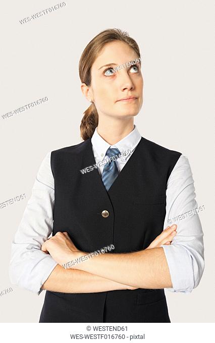 Close up of young air stewardess with arms crossed against white background