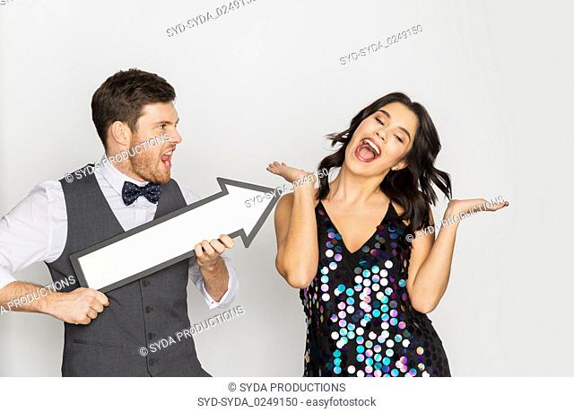 happy couple with big arrow at party