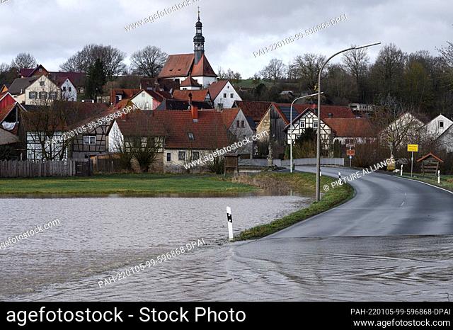 05 January 2022, Bavaria, Gleusdorf: A road is flooded by the high water of the Itz. The Itz has overflowed between Coburg and Bamberg
