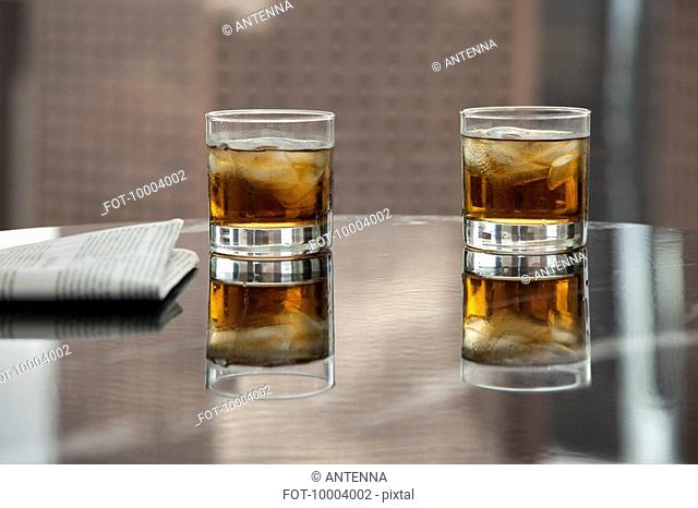 Two glasses of whiskey and ice on a table