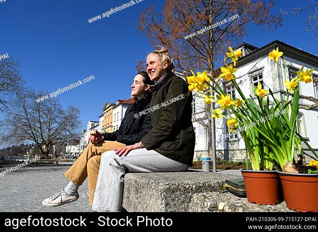 06 March 2021, Baden-Wuerttemberg, Ìberlingen Am Bodensee: Students Felicitas Mundorf (r) and Sophie Stielow sit next to their just-bought daffodils on the...
