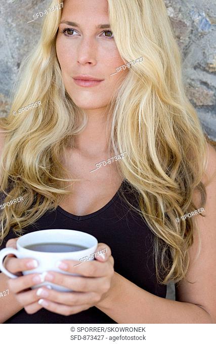 Blond woman holding a cup of tea