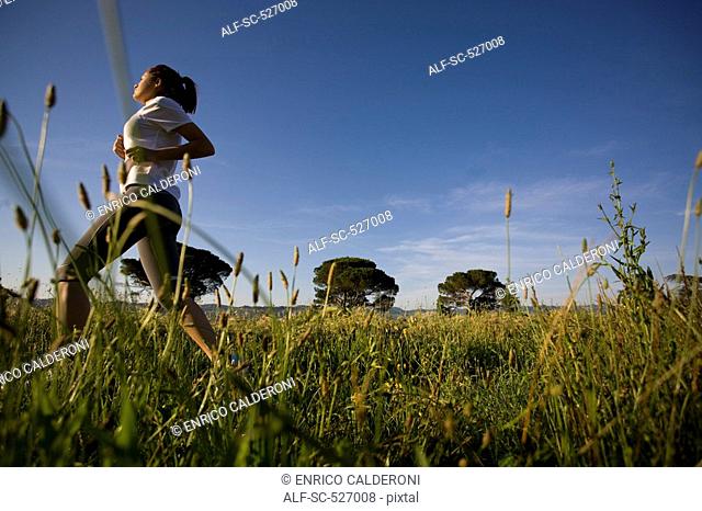 Teenager girl jogging in countryside