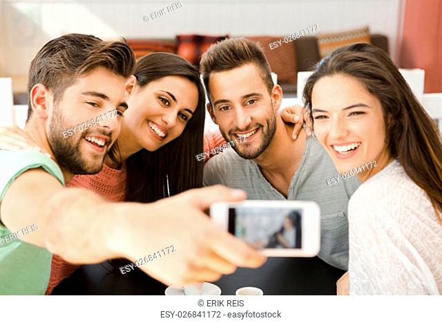 Group of friends at the coffee shop making a selfie together