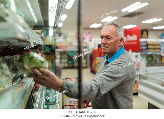 Senior man is buying fruit and vegetables in a supermarket