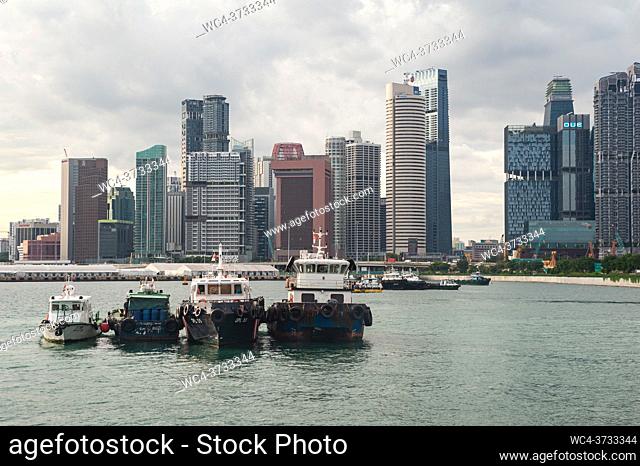 Singapore, Republic of Singapore, Asia - Boats at anchor in front of skyscrapers of the business and financial district along Shenton Way and Anson Road in the...