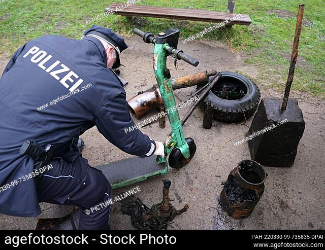 30 March 2022, Hamburg: A police officer checks an e-scooter found by divers during the trash dive in the Alster. During the city cleaning campaign ""Hamburg...