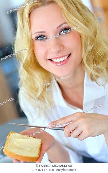 Beautiful girl eating toasted bread for breakfast
