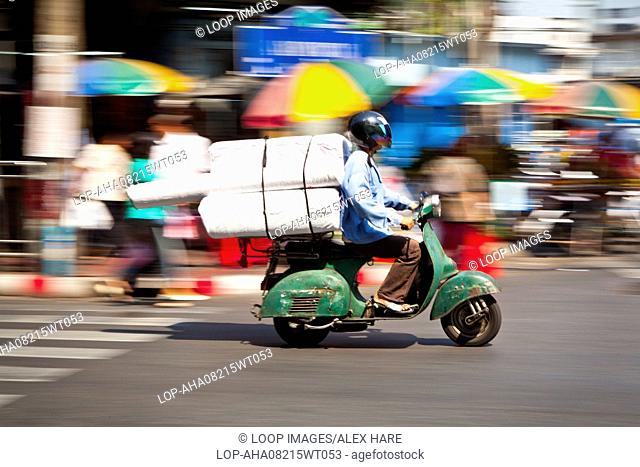A motor scooter passing along a road in Bangkok