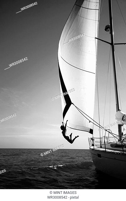 Woman jumping from a yacht into the ocean