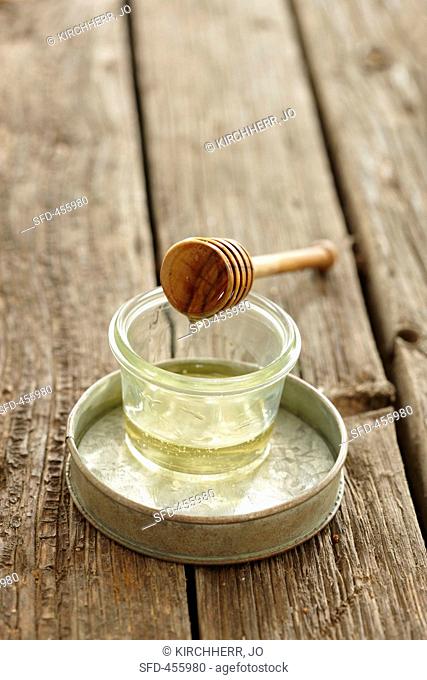 A jar of honey and a honey spoon