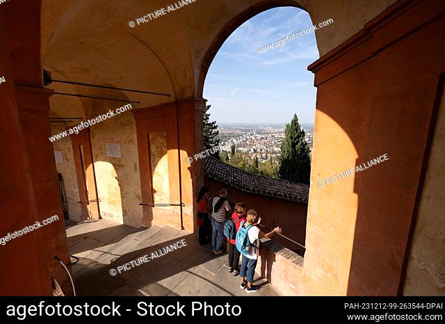 14 October 2023, Italy, Bologna: Visitors look out over Bologna from the arcades of the Santuario della Madonna di San Luca church