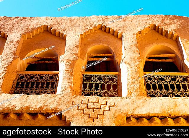 orange  window in morocco africa old construction and brown wall red carpet