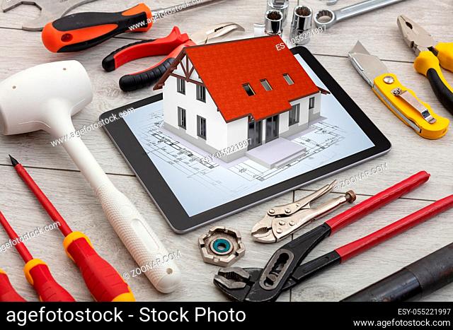 Tablet with construction tools and 3d home plan concept