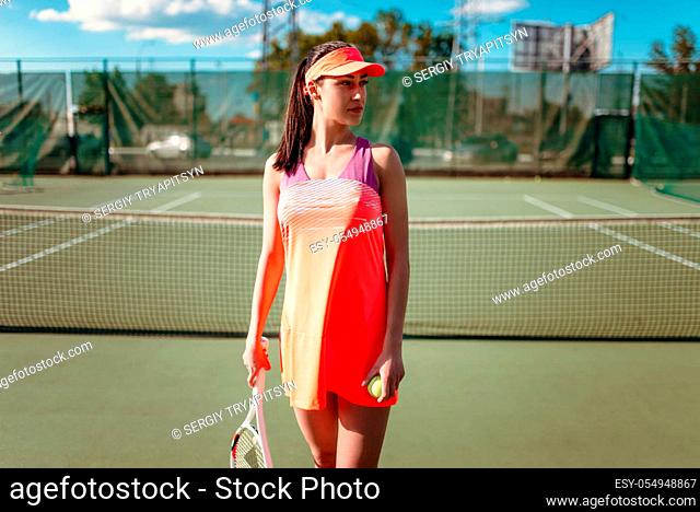 Attractive female tennis player on outdoor court. Summer season active sport game