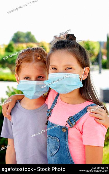 Little child girls friends in protection mask outdoor
