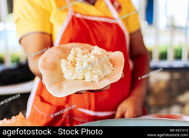 Preparation of the dough for traditional Nicaraguan pupusas, Elaboration of traditional pupusas, Hands of a vendor showing traditional raw pupusa