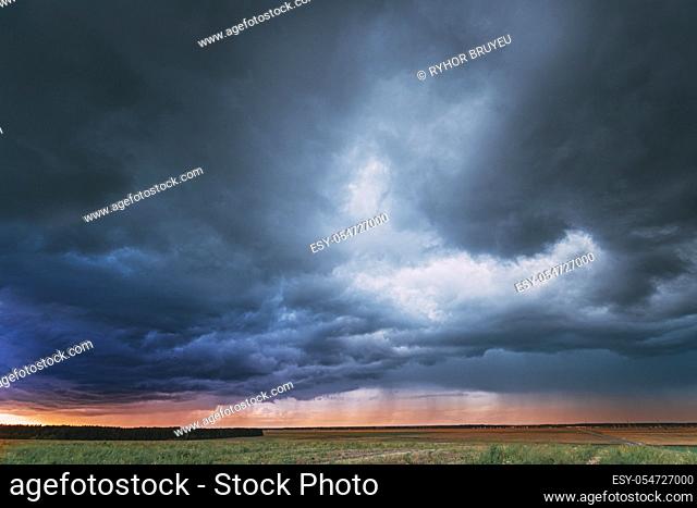 Summer Rainy Sunset Evening Above Rural Field Landscape. Scenic Dramatic Sky With Rain Clouds. Agricultural And Weather Forecast Concept