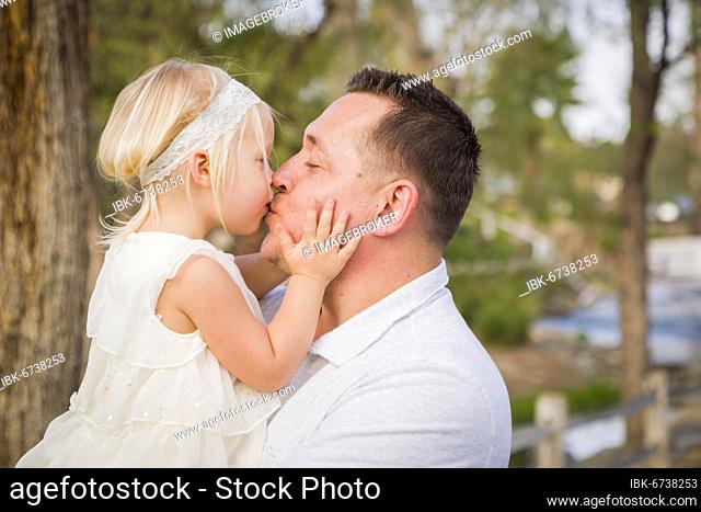 Affectionate father playing with cute baby girl outside at the park