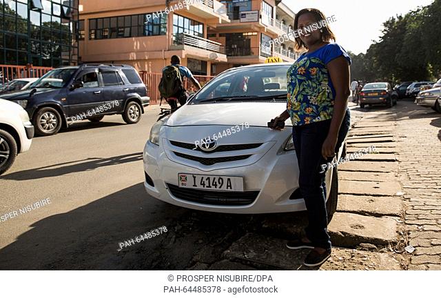 Taxi driver Melissa Kwizera inspects her 'Hello Taxi' in Bujumbura, Burundi,  19 November 2015. Kwizera is one of the few winners of the political crisis in...