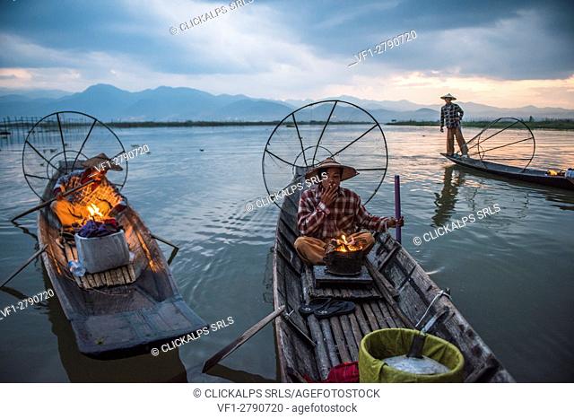 Inle lake, Nyaungshwe township, Taunggyi district, Myanmar (Burma). Local fisherman before dawn with fireplace on the boat