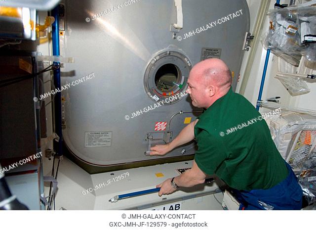 European Space Agency astronaut Andre Kuipers, Expedition 30 flight engineer, closes a hatch in the International Space Station as crew members prepare to move...
