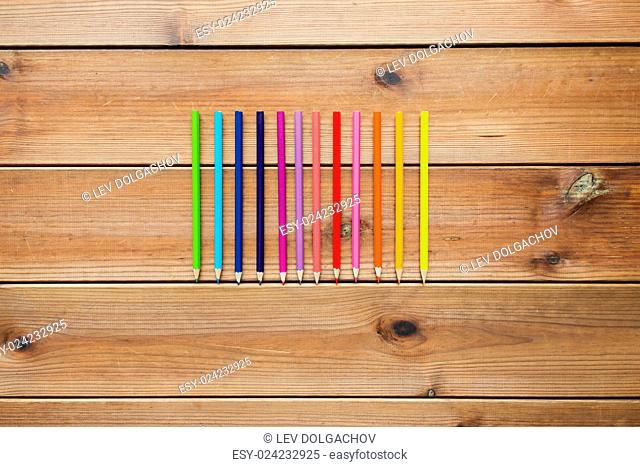 art, color, drawing, creativity and object concept - close up of crayons or color pencils on wooden table
