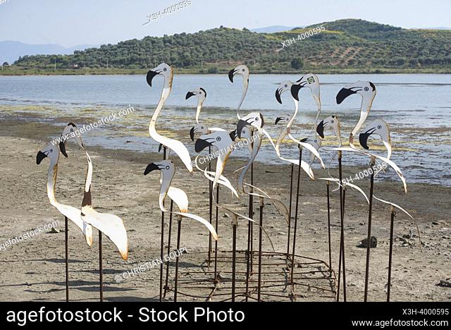 Artificial flamingos arranged near the wooden bridge connecting to the Bysantine Zvernec Monastery on Zvernec Island within the Narta Lagoon