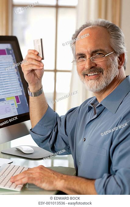 Businessman Sitting at Computer With Credit Card