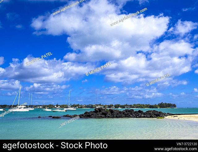 Blue sky with dramatic clouds over turquoise waters of Grand Baie, Mauritius. Grand Baie (or Grand Bay) is a seaside village and large tourist beach attraction...