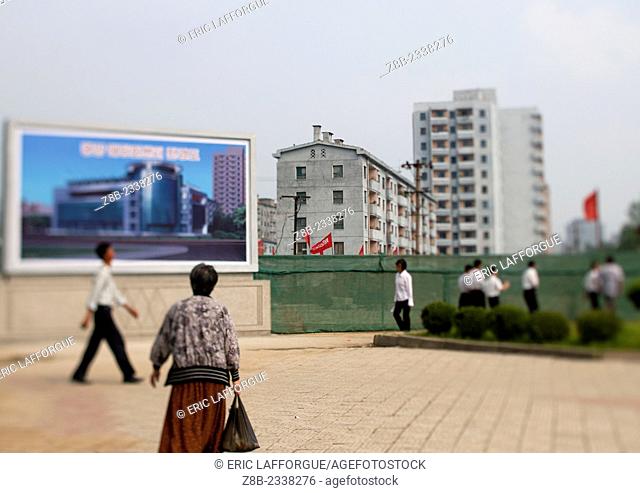 People Walking Past Propaganda Poster, Pyongyang, North Korea