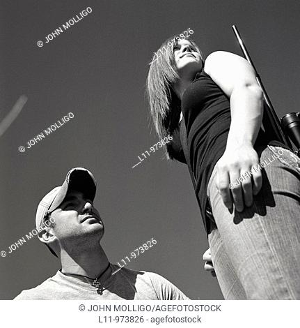 Man and woman with rifle, looking right