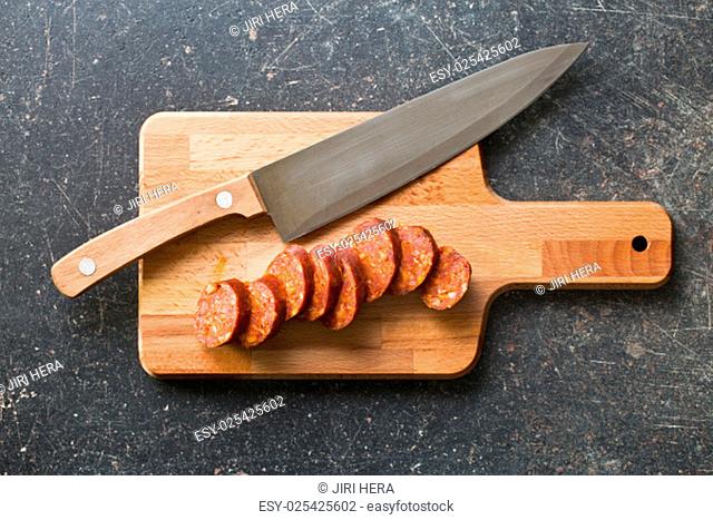 sliced dried sausages on old kitchen table
