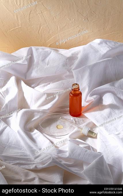 bottle of serum and dropper on white sheet