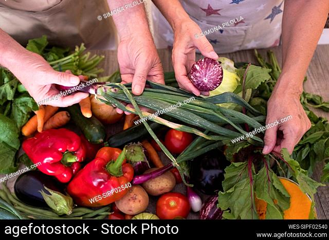 Couple checking vegetables while working in kitchen