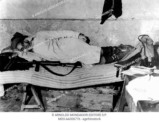 Salvatore Giuliano sleeping next to his shotgun. The bandit and Sicilian independence supporter Salvatore Giuliano sleeping with his rifle