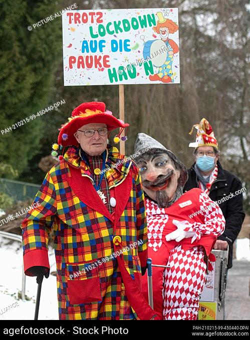 15 February 2021, North Rhine-Westphalia, Unna: Carnivalist Helmut Scherer waves at what is probably the world's smallest Rose Monday procession