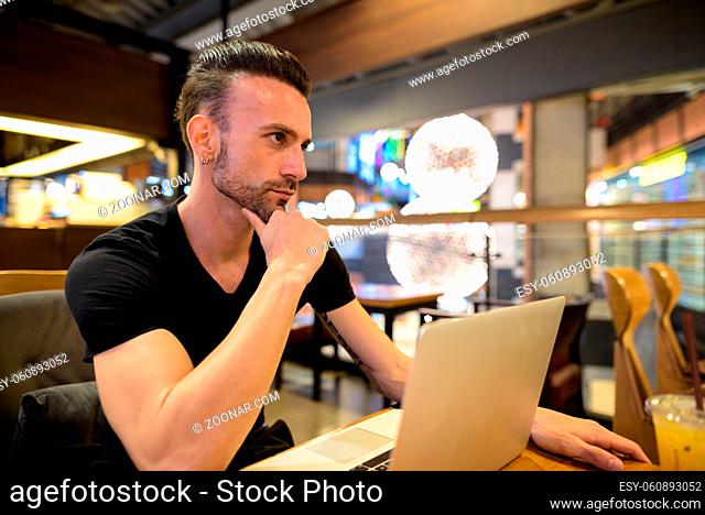 Portrait of handsome man sitting indoors at coffee shop
