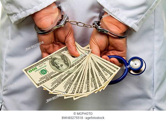doctor in handcuffs with stethoscope and 100 Dollar bills in his hands