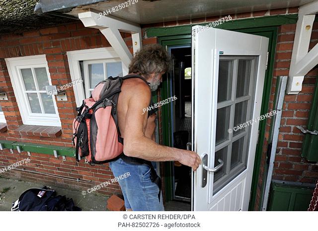 Knud Knudsen walks into a house on the Hallig of Suederoog, Germany, 13 July 2016. The 61-year-old man is Germany's only Wadden Sea mailman