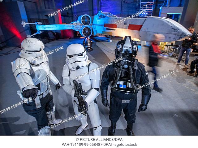 09 November 2019, Mecklenburg-Western Pomerania, Dassow: Members of Legion501 dressed up as tank, storm and shoretrooper are standing in front of the replica of...