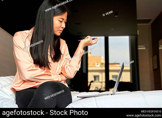 Businesswoman brainstorming while using laptop in hotel