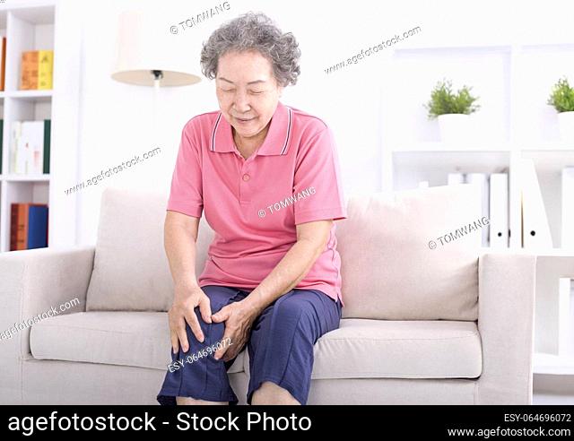 Asian senior woman sitting on sofa and having the joint pain