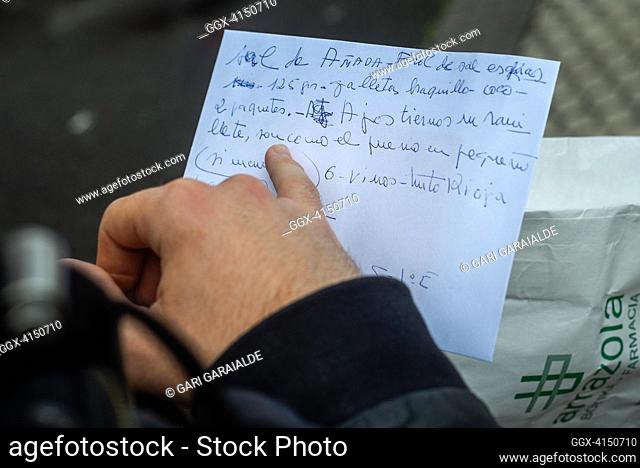 Aitor, a volunteer member of the Donostia Helping Network, reads the shopping list that Rosario has made for himDonostia (Spain). April 7, 2020