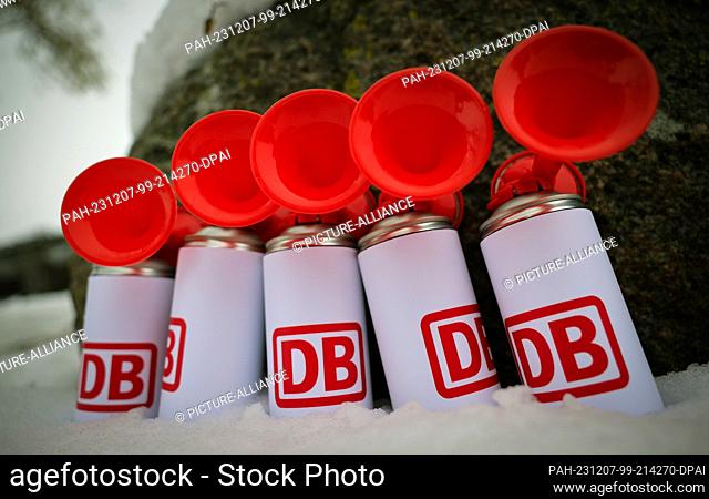 07 December 2023, Schleswig-Holstein, Fehmarn: Horn cans with the Deutsche Bahn (DB) logo stand next to the venue before a Deutsche Bahn ceremony