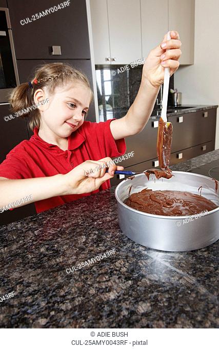 Girl pouring cake mix into cake tin